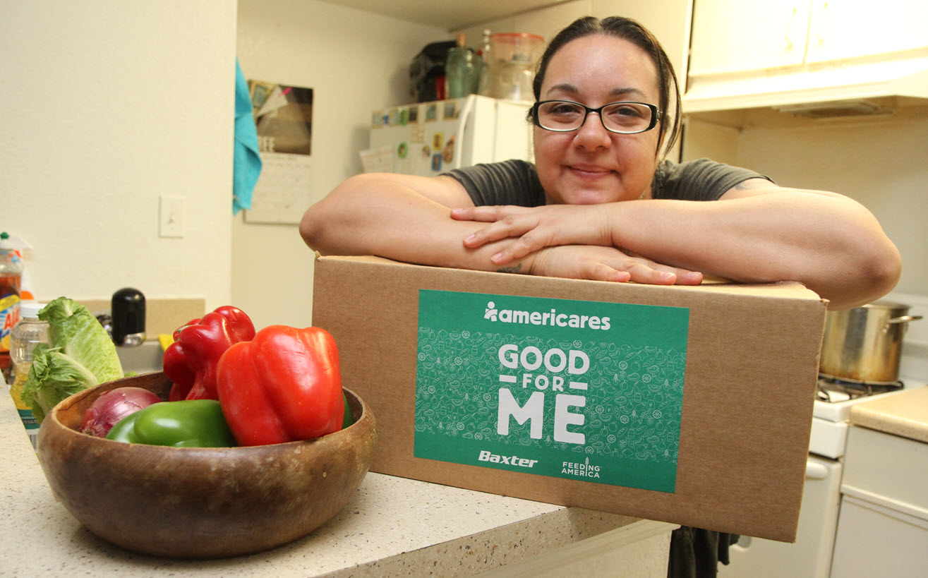 Image of women posing with a box of nutritious food